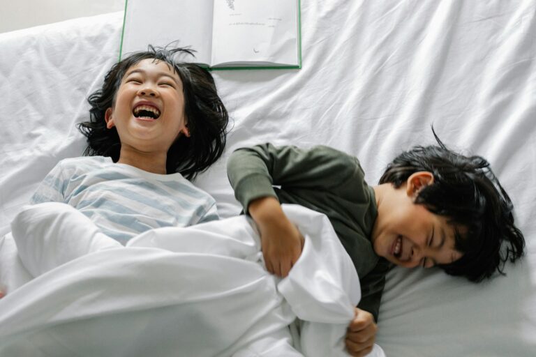 Smiling asian kids in bed